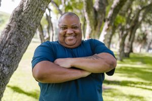 Portrait of a cheerful man enjoying a sunny day outdoors in a park.
